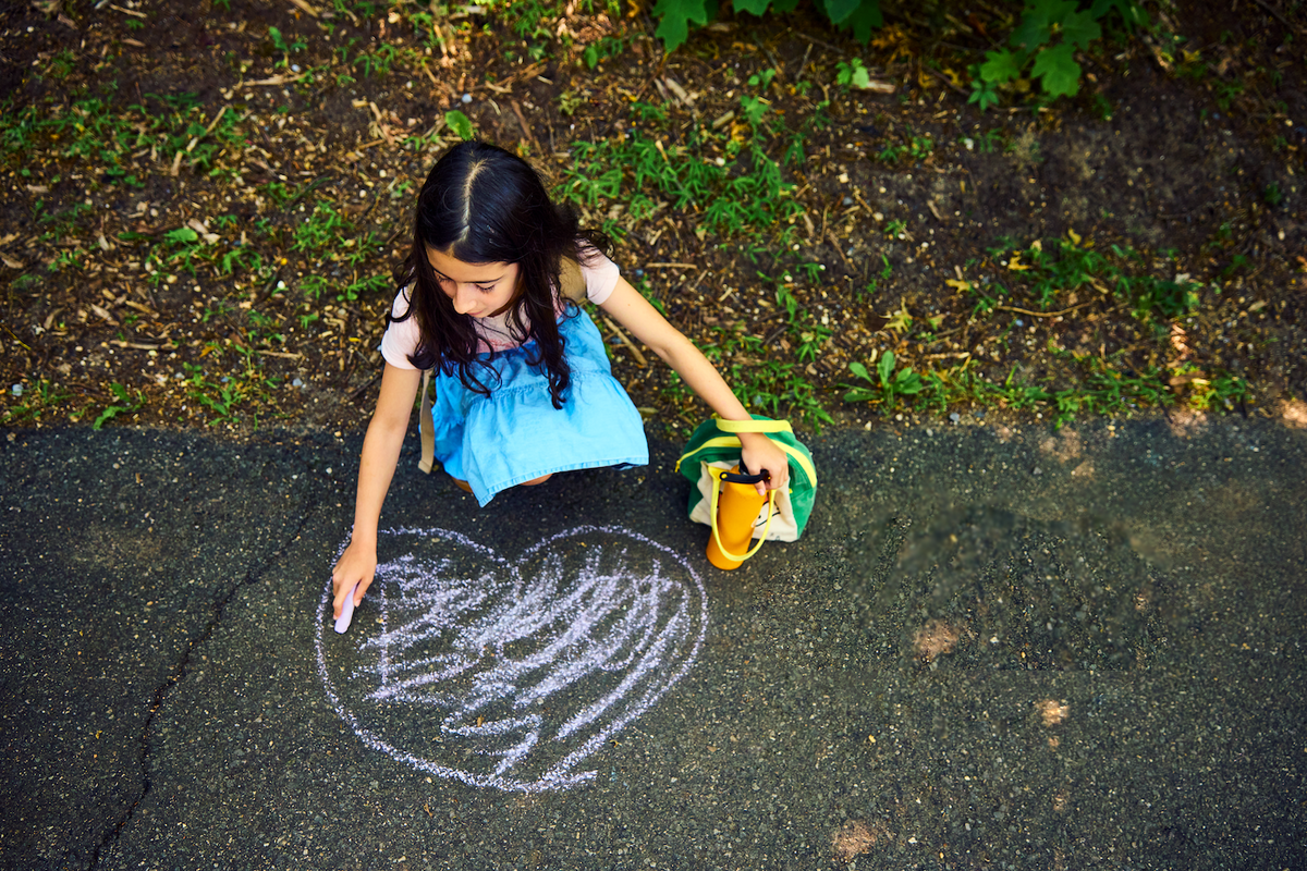 Usdan Student draws heart with chalk