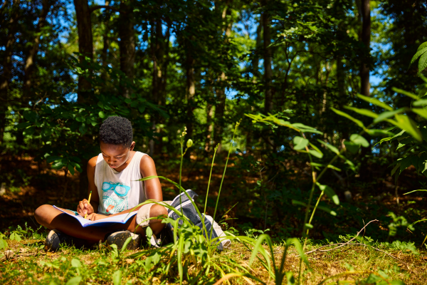 Student writing camp in the woods of Long island