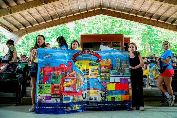 Students standing with City of Usdan artwork