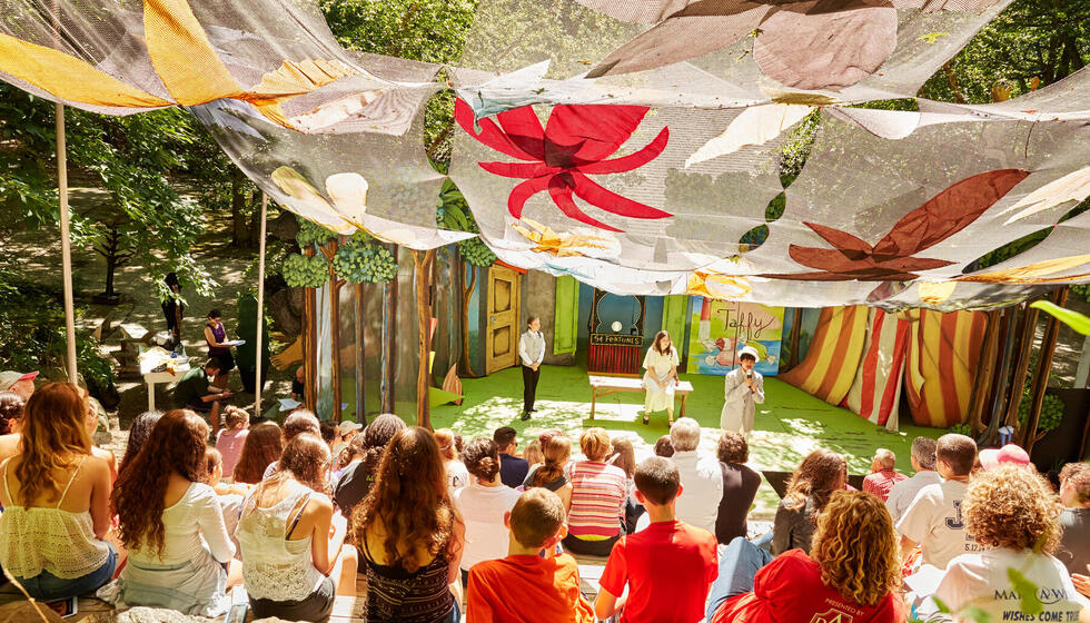 Usdan students watching a theater production in an outdoor theater.