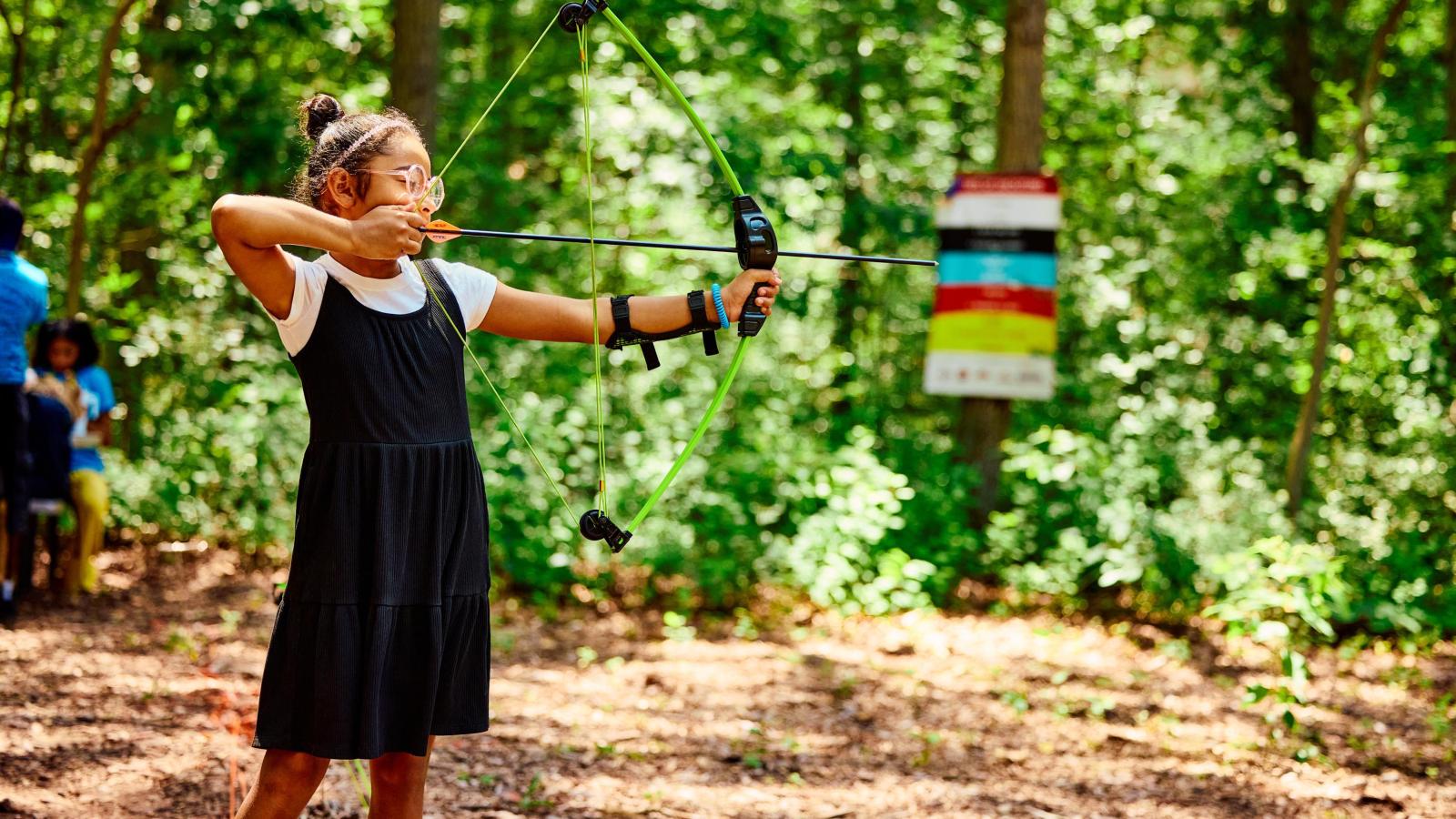 Girl shooting a bow & arrow, Archery 