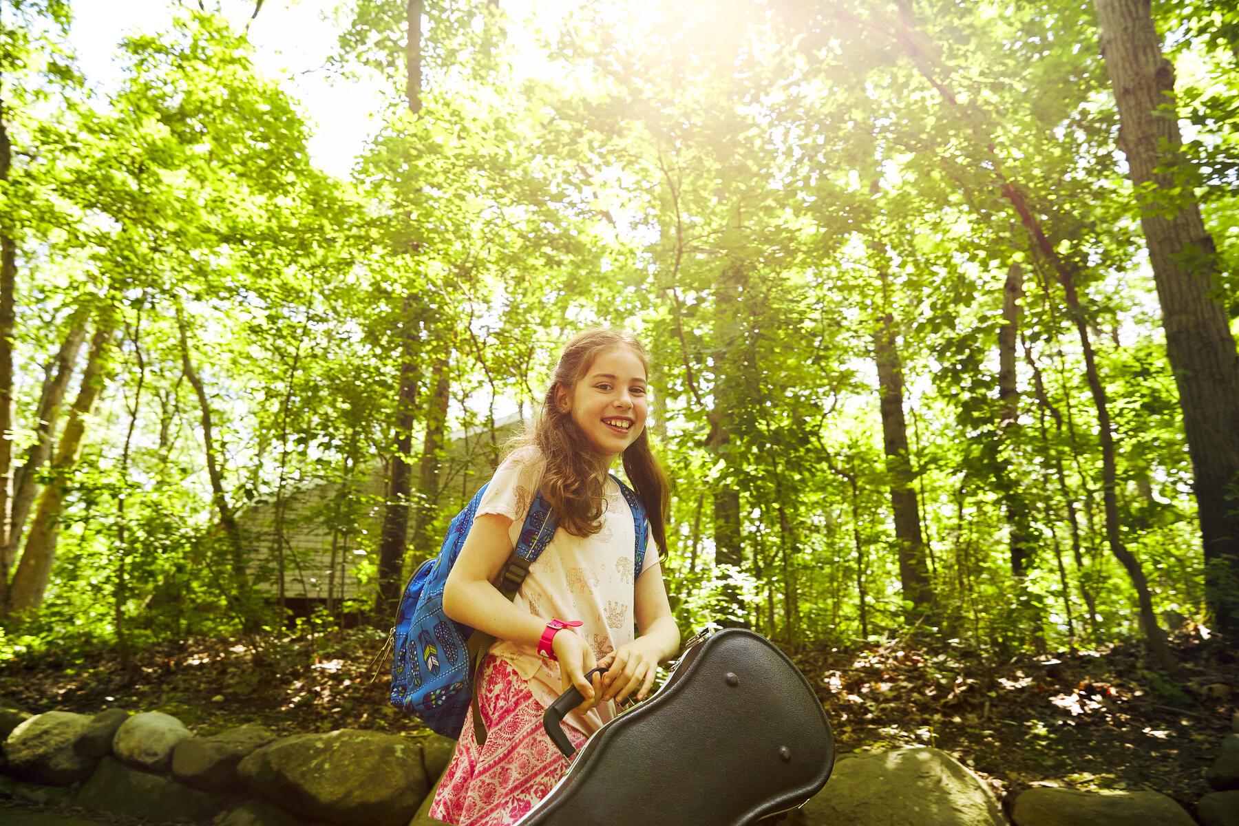 Girl in the woods holding a violin 