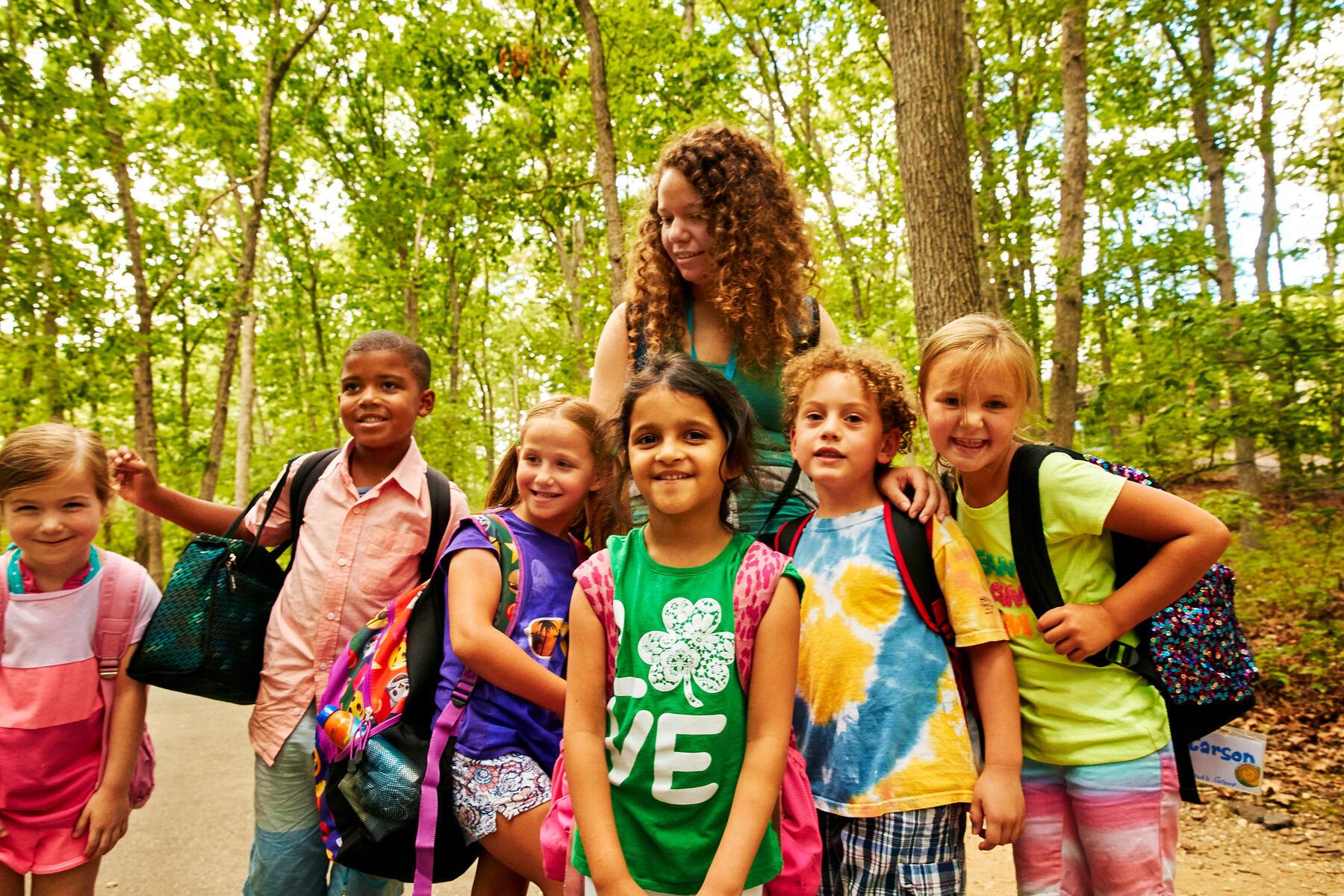 Group of children standing in the woods smiling