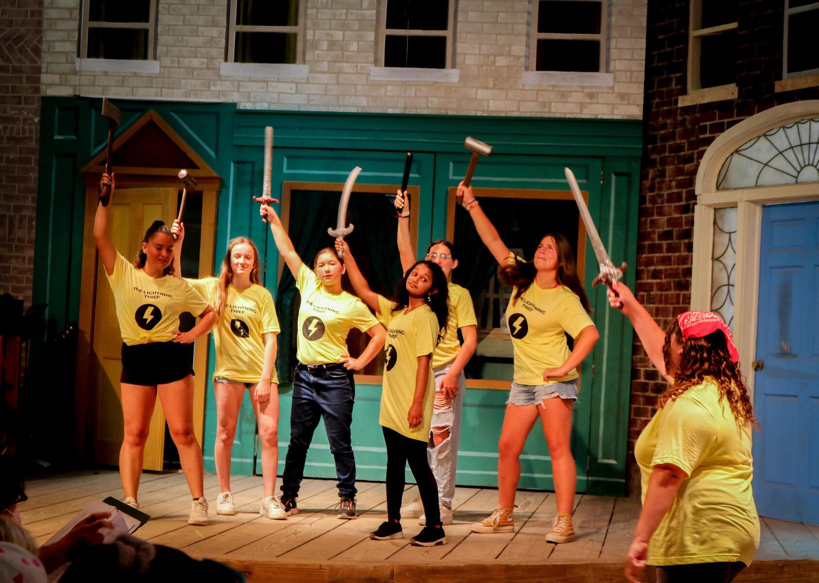 students on stage with swords