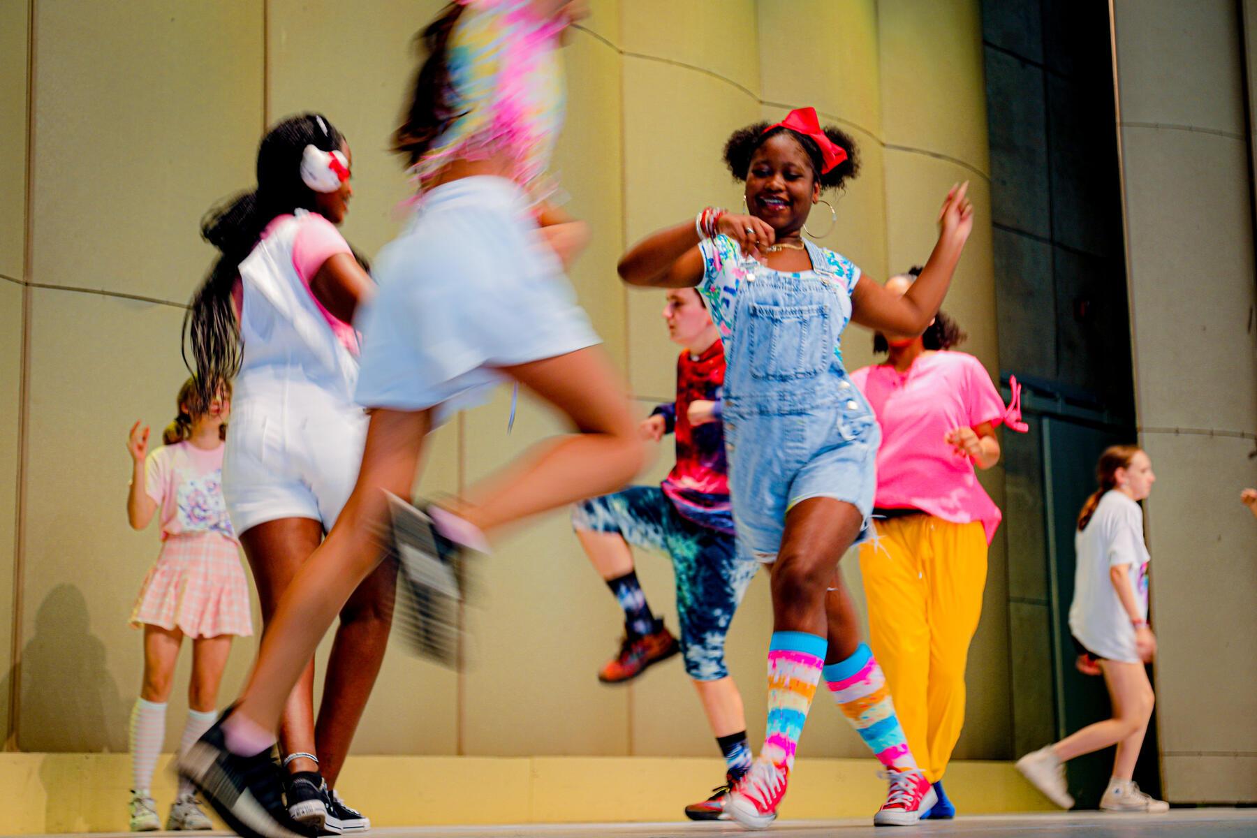 Group of students dancing in a circle on stage