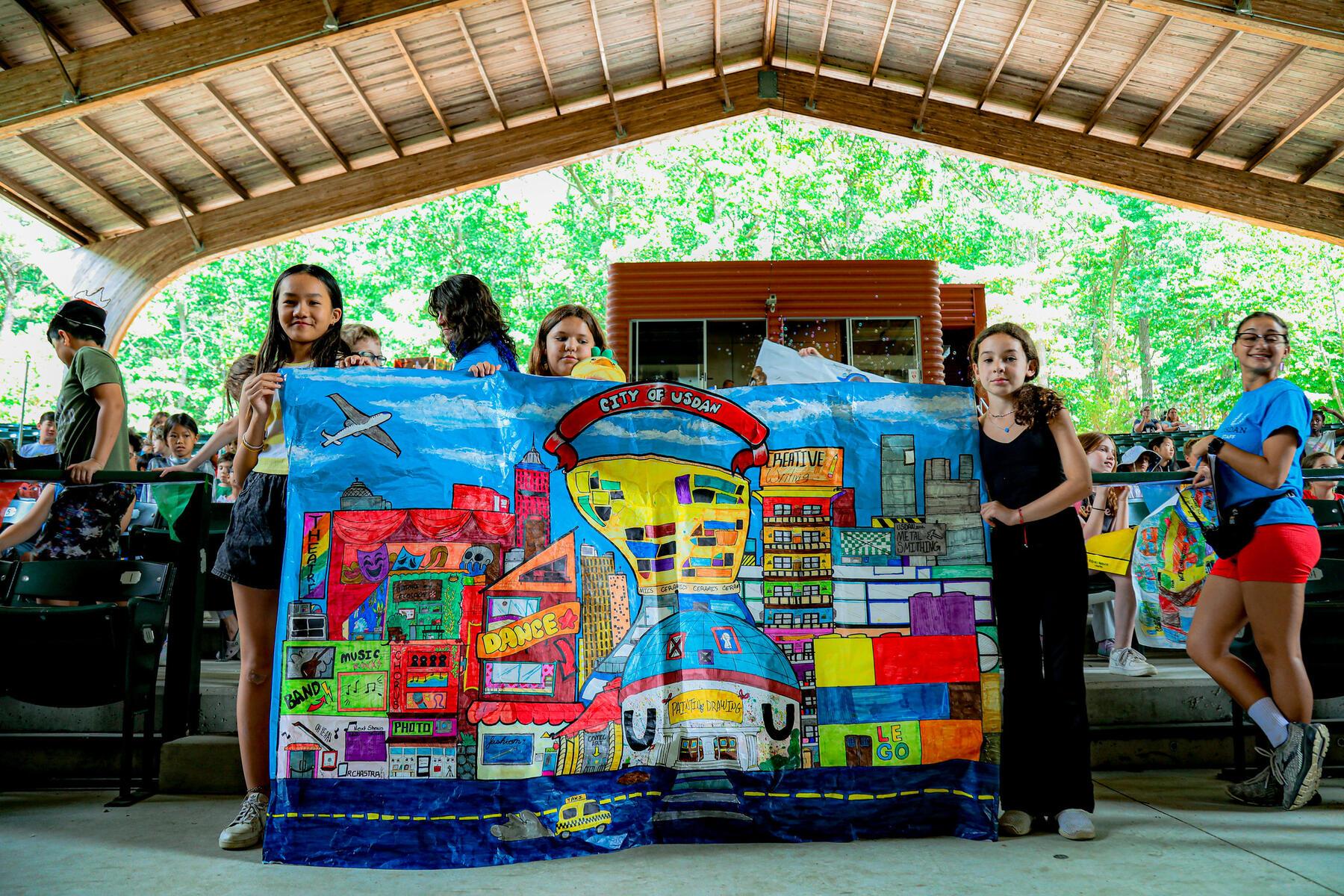Students standing with City of Usdan artwork