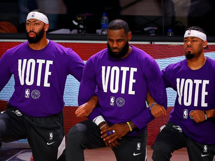 Los Angeles Lakers players Davis, James, and Cook kneel during the national anthem befo