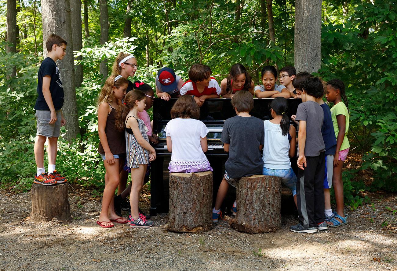 Usdan student performs for a surrounding group of kids