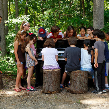 Usdan student performs for a surrounding group of kids